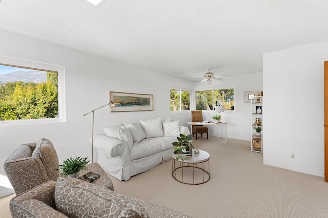 carpeted living room with ceiling fan, a textured ceiling, and a healthy amount of sunlight