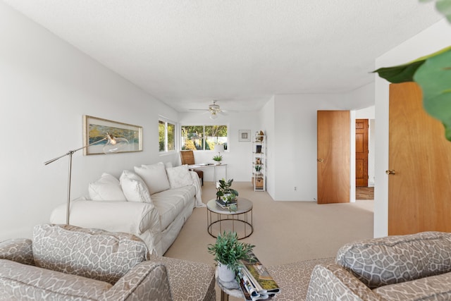 carpeted living room featuring a textured ceiling and ceiling fan