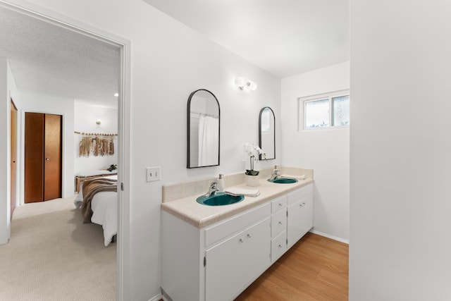 bathroom with vanity, hardwood / wood-style floors, and a textured ceiling