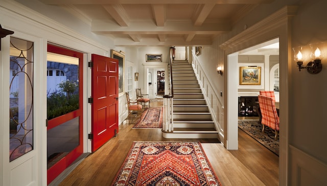 entrance foyer featuring beamed ceiling and light hardwood / wood-style flooring