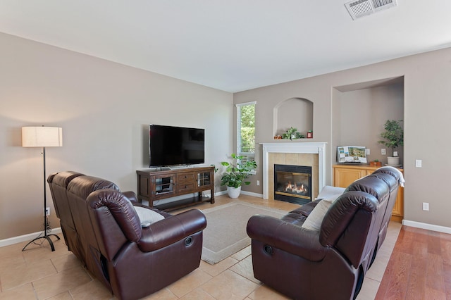 living room with light hardwood / wood-style flooring and a tile fireplace