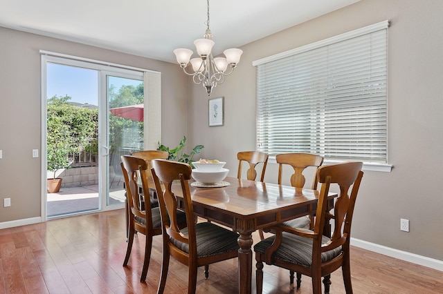 dining room with hardwood / wood-style floors and an inviting chandelier