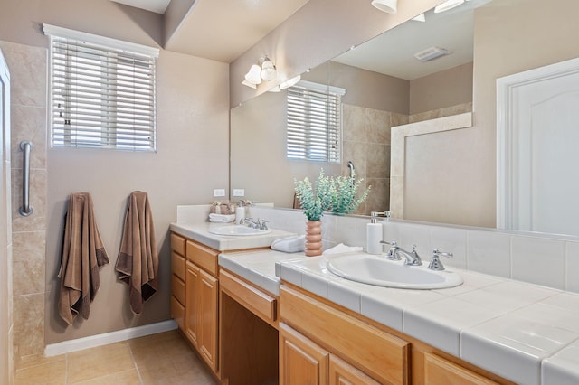 bathroom with vanity, tile patterned flooring, and tiled shower