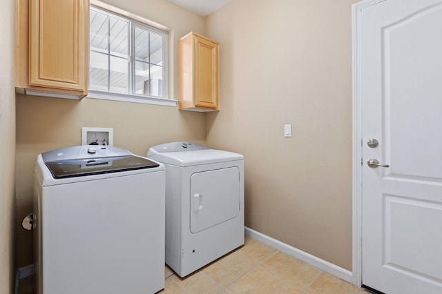 clothes washing area with light tile patterned floors, cabinets, and washer and dryer