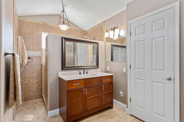 bathroom featuring lofted ceiling, tile patterned floors, a tile shower, and vanity