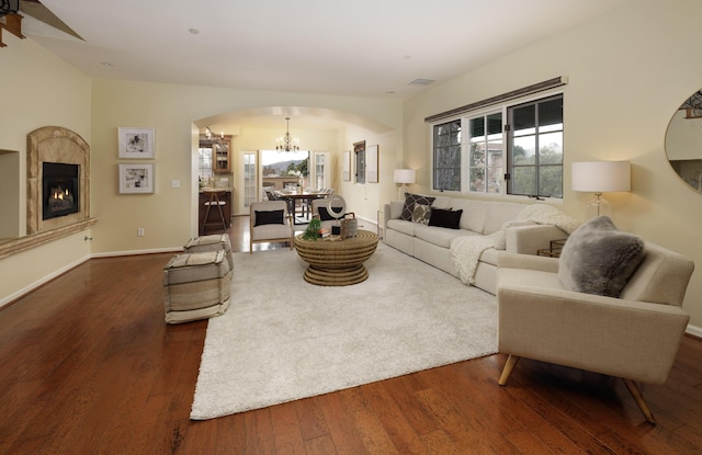 living room with an inviting chandelier and dark wood-type flooring