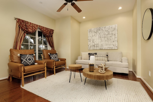 living area with ceiling fan and dark hardwood / wood-style flooring