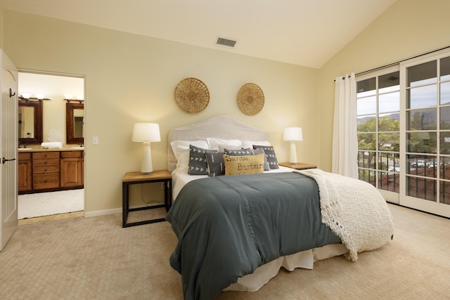 carpeted bedroom with ensuite bathroom, access to exterior, and vaulted ceiling