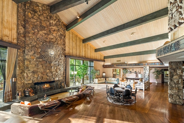 interior space featuring a stone fireplace, dark wood-type flooring, wood ceiling, high vaulted ceiling, and beam ceiling