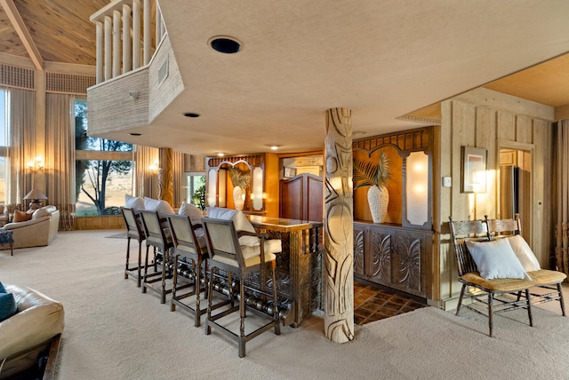 carpeted dining area with wood walls