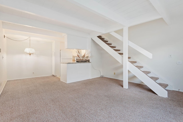 unfurnished living room featuring beamed ceiling and light colored carpet