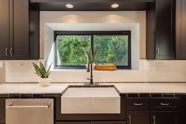 kitchen featuring dark brown cabinetry, sink, and decorative backsplash