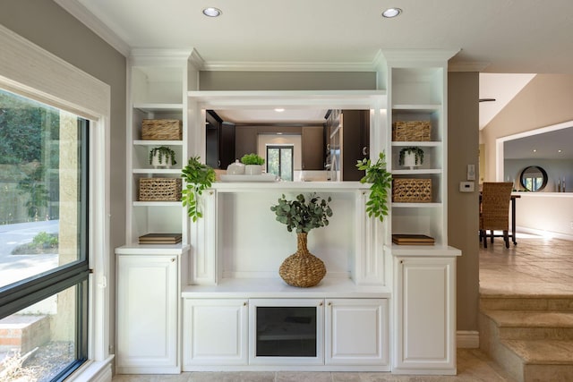 bar with white cabinets and crown molding