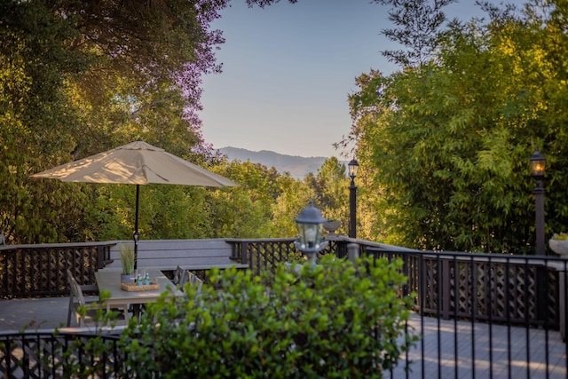 deck at dusk featuring a mountain view