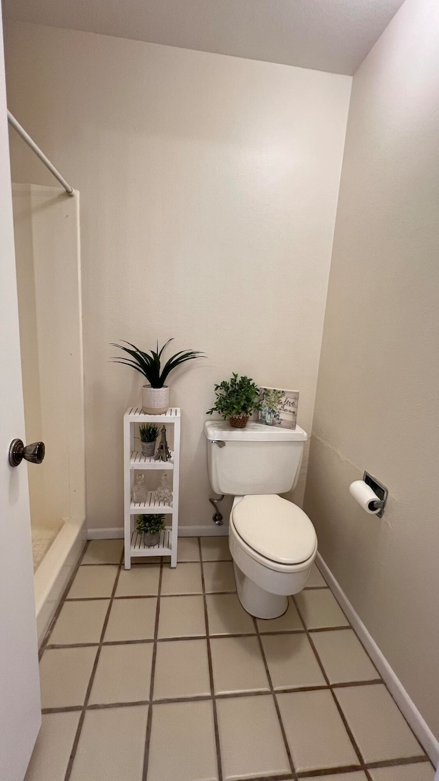 bathroom with walk in shower, tile patterned flooring, and toilet