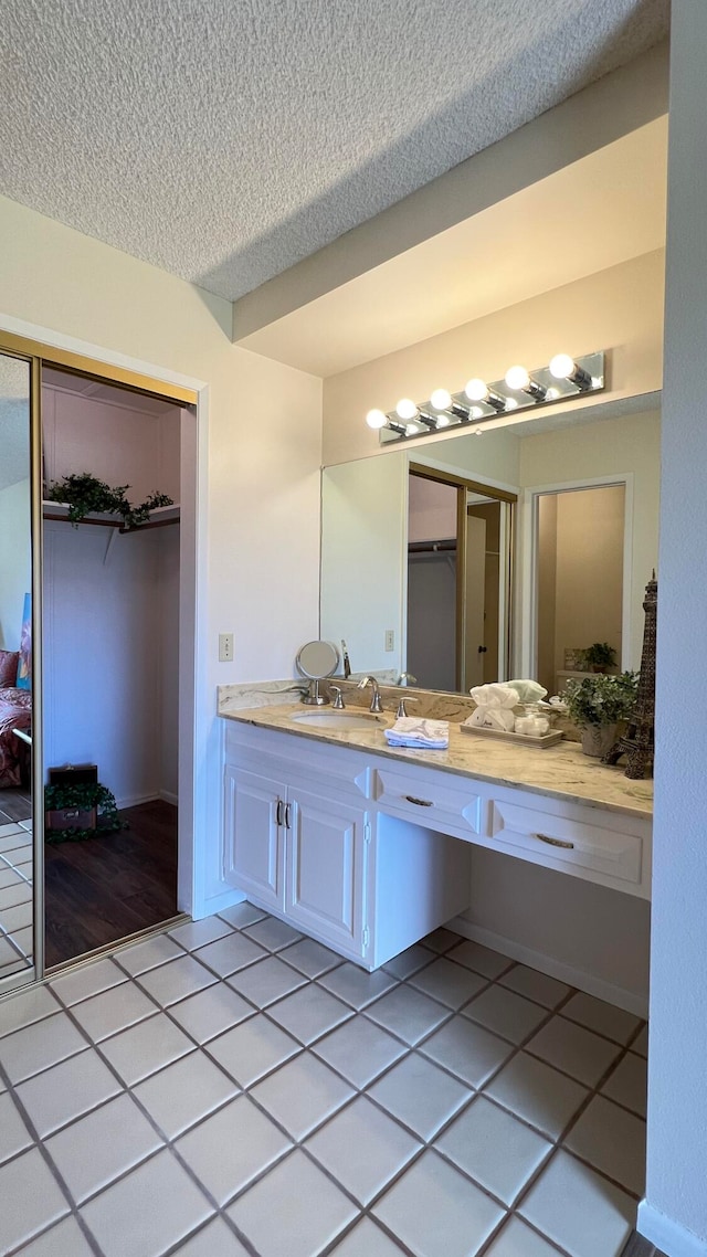 bathroom featuring vanity, a textured ceiling, and tile patterned flooring