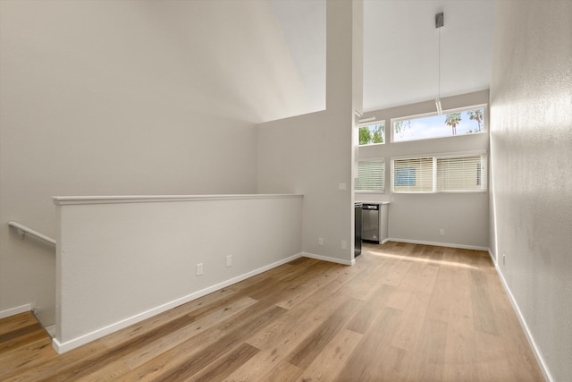 unfurnished living room with light hardwood / wood-style flooring and high vaulted ceiling