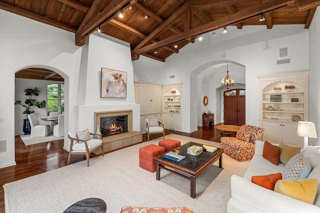 living room with beam ceiling, a tile fireplace, high vaulted ceiling, wood-type flooring, and wood ceiling