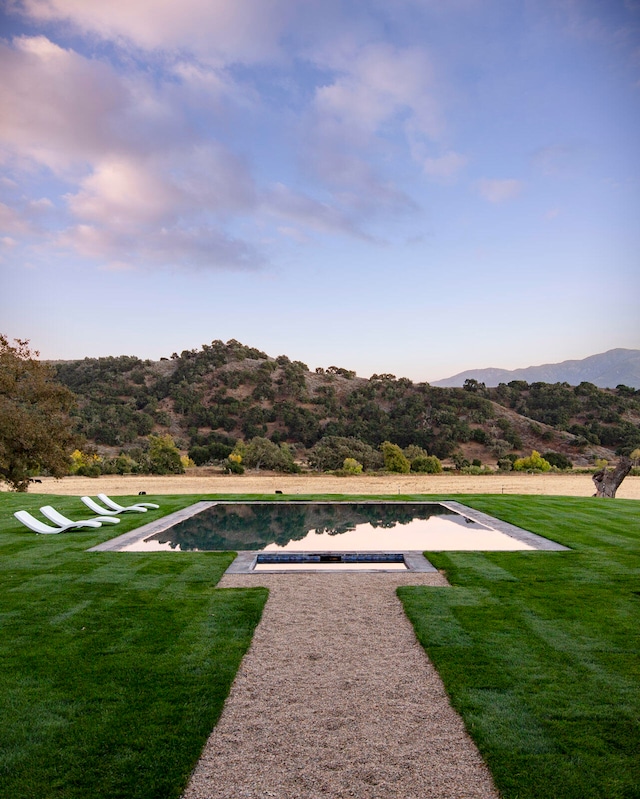 view of home's community featuring a lawn and a water and mountain view