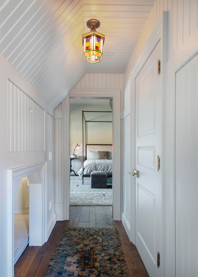 hall featuring dark hardwood / wood-style flooring and vaulted ceiling