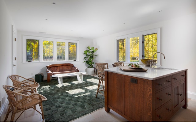 interior space featuring sink, light tile patterned floors, a healthy amount of sunlight, and french doors