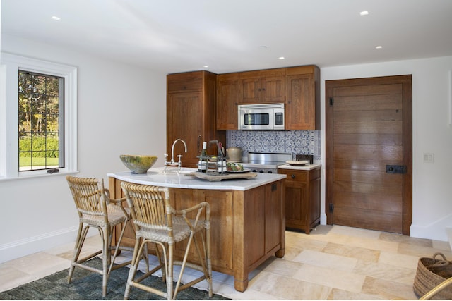 5200 Armour Ranch Rd, Santa Ynez, CA 93460 - kitchen with stainless steel microwave, light countertops, decorative backsplash, brown cabinets, and recessed lighting