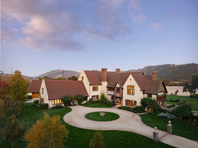 view of front of property with a lawn and a mountain view