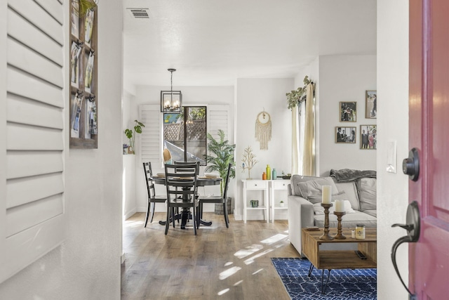 living room featuring wood-type flooring and a notable chandelier