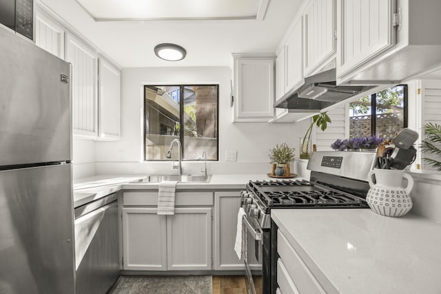 kitchen featuring a wealth of natural light, sink, white cabinets, and appliances with stainless steel finishes