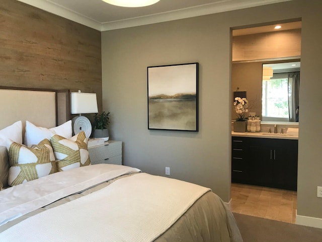 bedroom with ensuite bathroom, ornamental molding, and sink