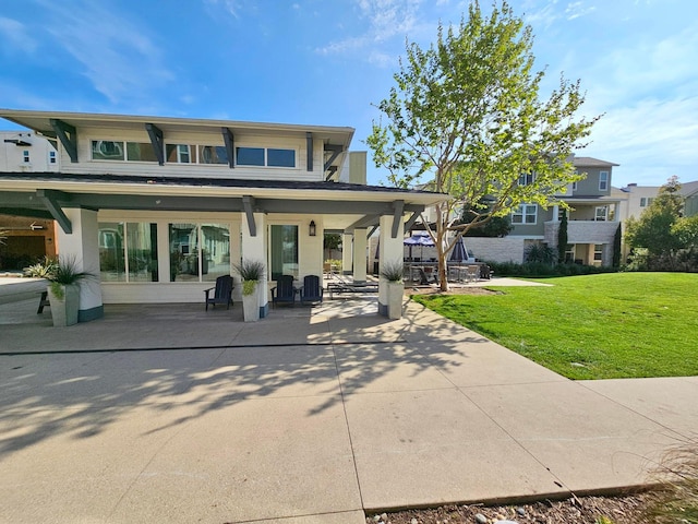 rear view of house featuring a patio area and a yard