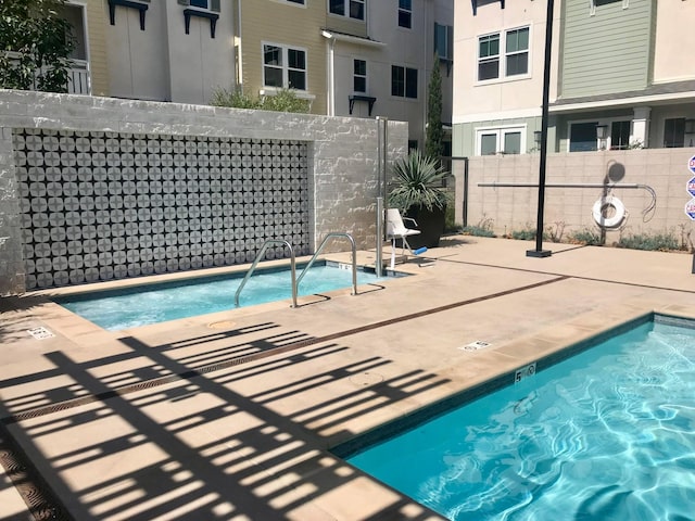 view of pool with a patio area and a hot tub