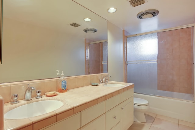 full bathroom featuring vanity, bath / shower combo with glass door, tile patterned flooring, decorative backsplash, and toilet