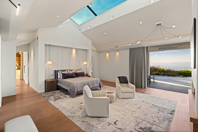 bedroom with access to outside, high vaulted ceiling, and hardwood / wood-style flooring