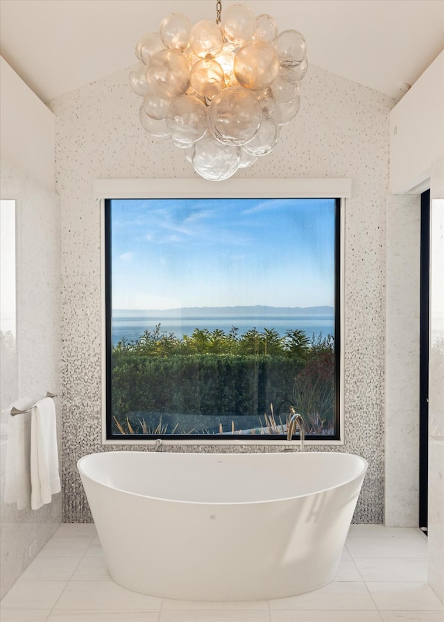 bathroom featuring tile patterned flooring, a bath, and lofted ceiling