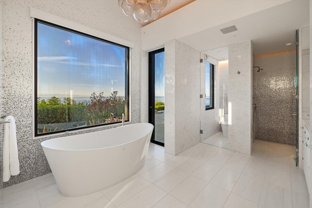 bathroom with tile patterned floors, plenty of natural light, independent shower and bath, and toilet