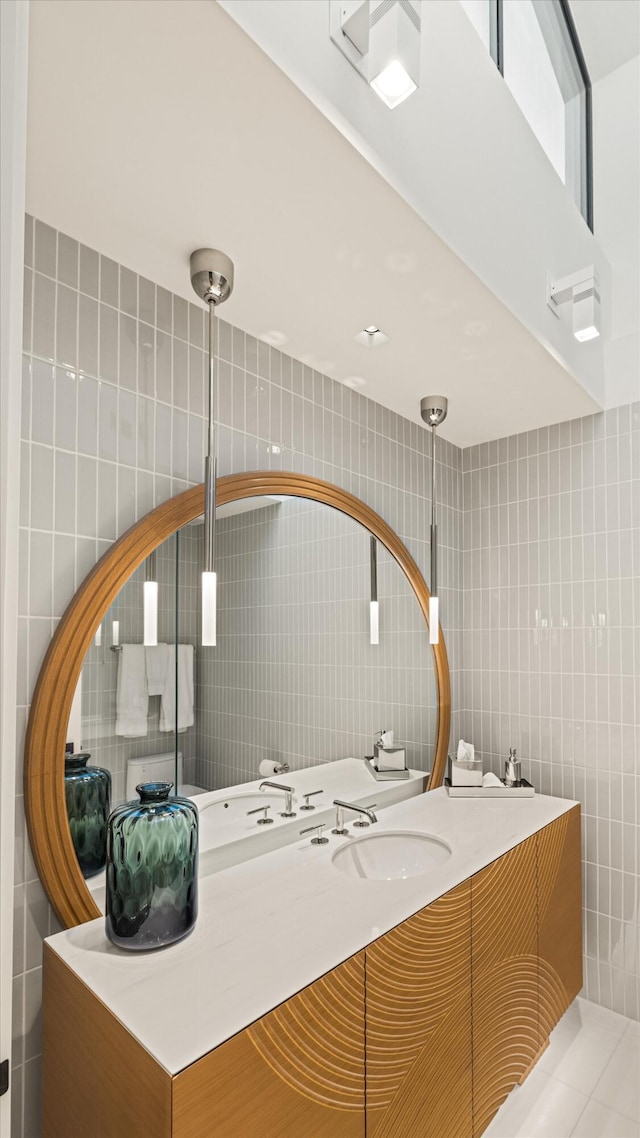 bathroom featuring tile patterned flooring, vanity, and tile walls