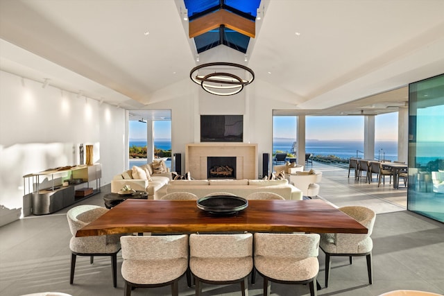 dining space featuring a healthy amount of sunlight, a water view, and vaulted ceiling