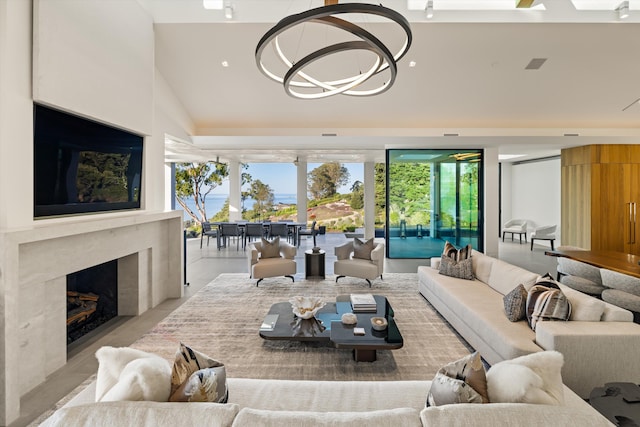 living room featuring a chandelier, vaulted ceiling, and a premium fireplace