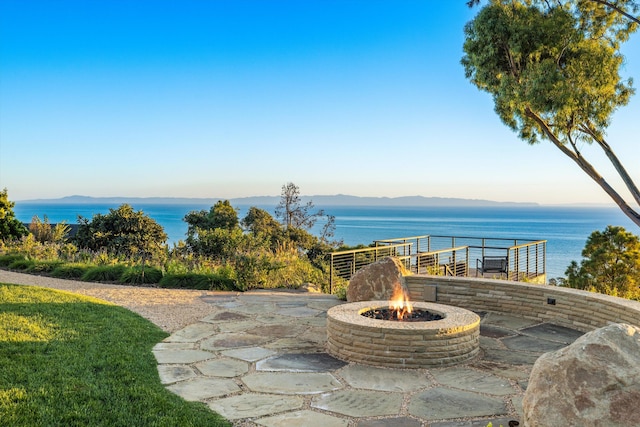 view of patio / terrace with a water and mountain view and an outdoor fire pit