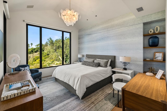 bedroom featuring hardwood / wood-style floors, a chandelier, and vaulted ceiling