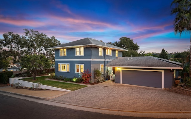 view of property with a garage and a lawn