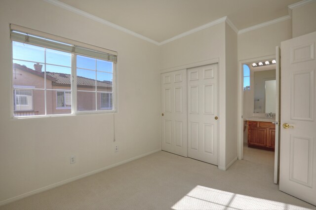 unfurnished bedroom featuring crown molding, a closet, and light colored carpet