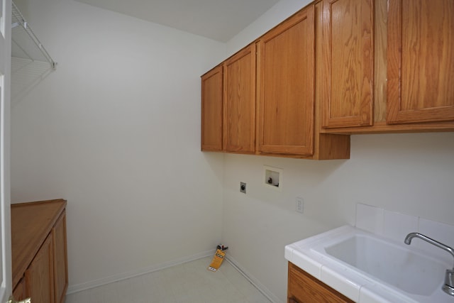 clothes washing area featuring cabinets, hookup for a washing machine, hookup for an electric dryer, and sink