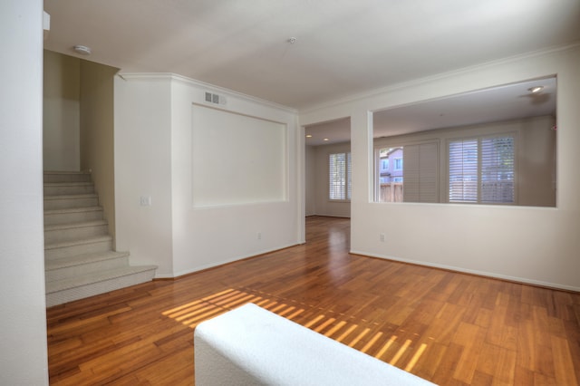 empty room featuring hardwood / wood-style floors and ornamental molding