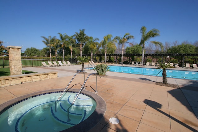 view of pool with a patio area and a hot tub