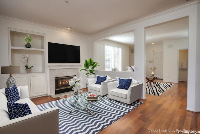 living room with hardwood / wood-style floors, crown molding, and a premium fireplace