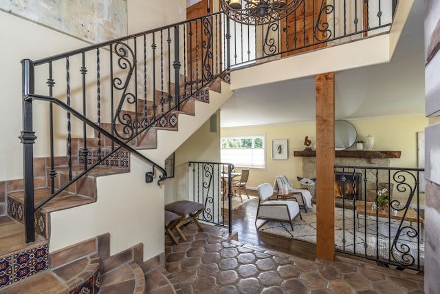 stairway featuring a fireplace and a high ceiling