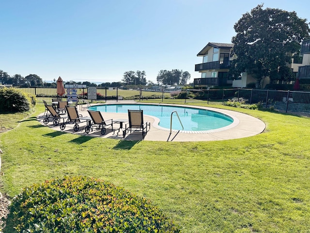 view of swimming pool featuring a yard