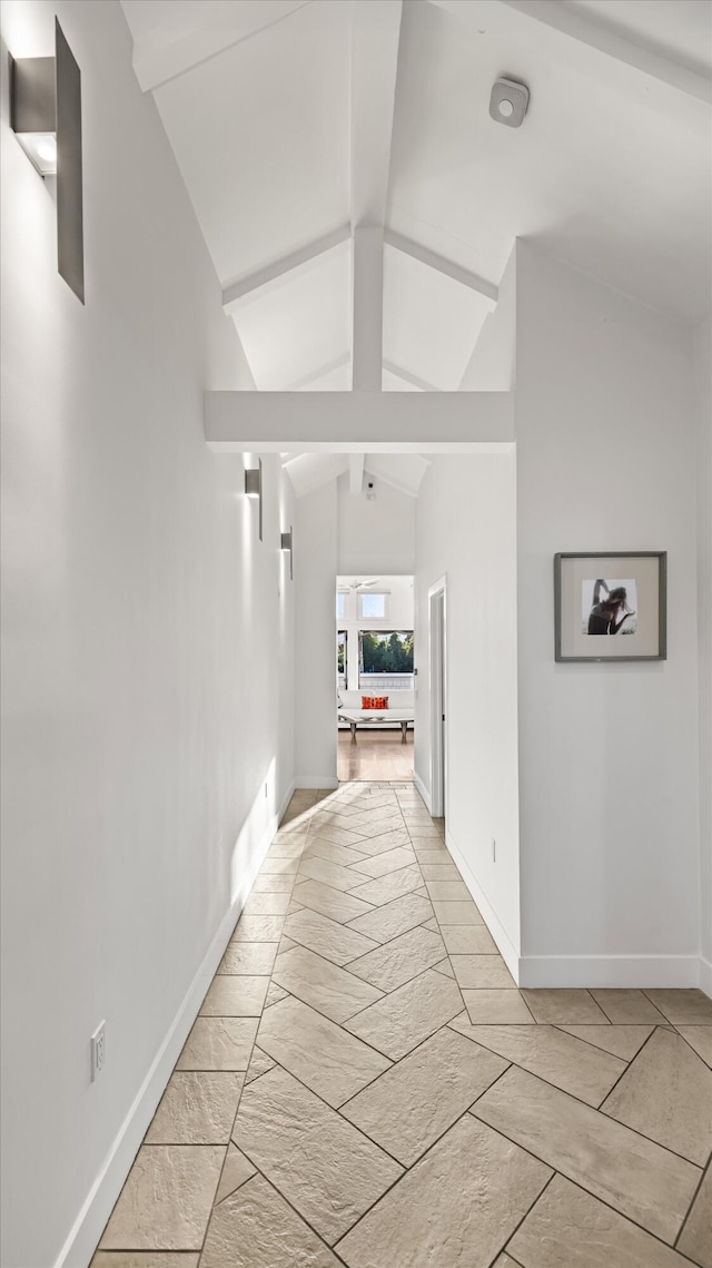 hall featuring vaulted ceiling with beams